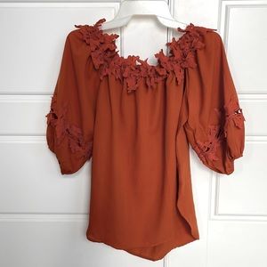 Orange leaf off the shoulder top. Medium fit.